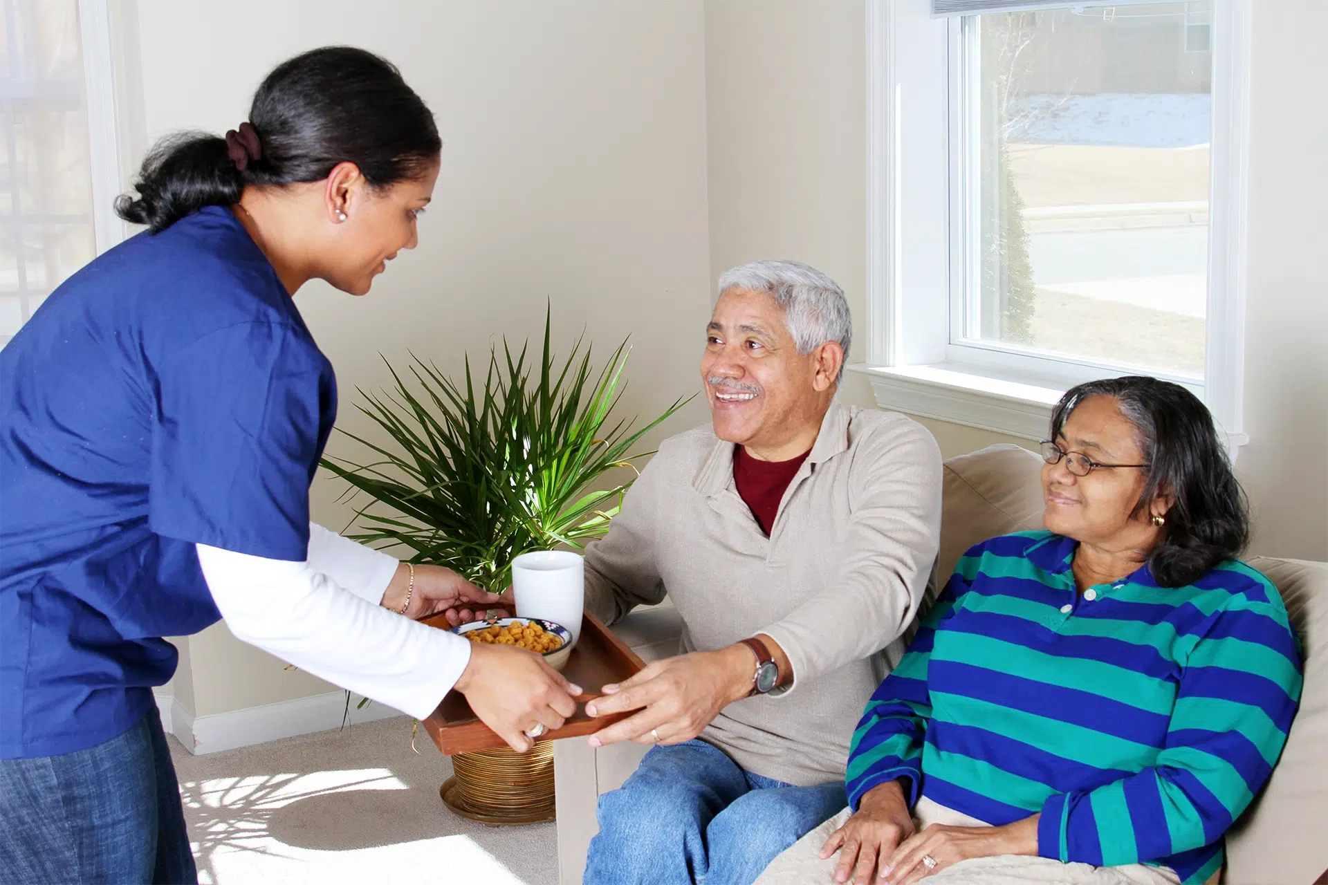 Texas home care aide providing personal support and meal assistance to an older couple at home.