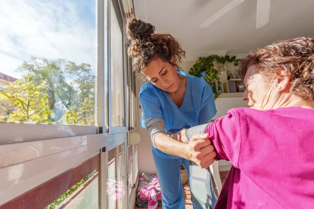 Texas home health nurse assisting an elderly woman with safe mobility during in-home care.
