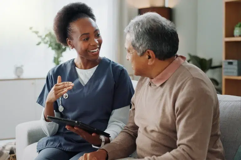 Home Health Aide assists senior man with understanding services.