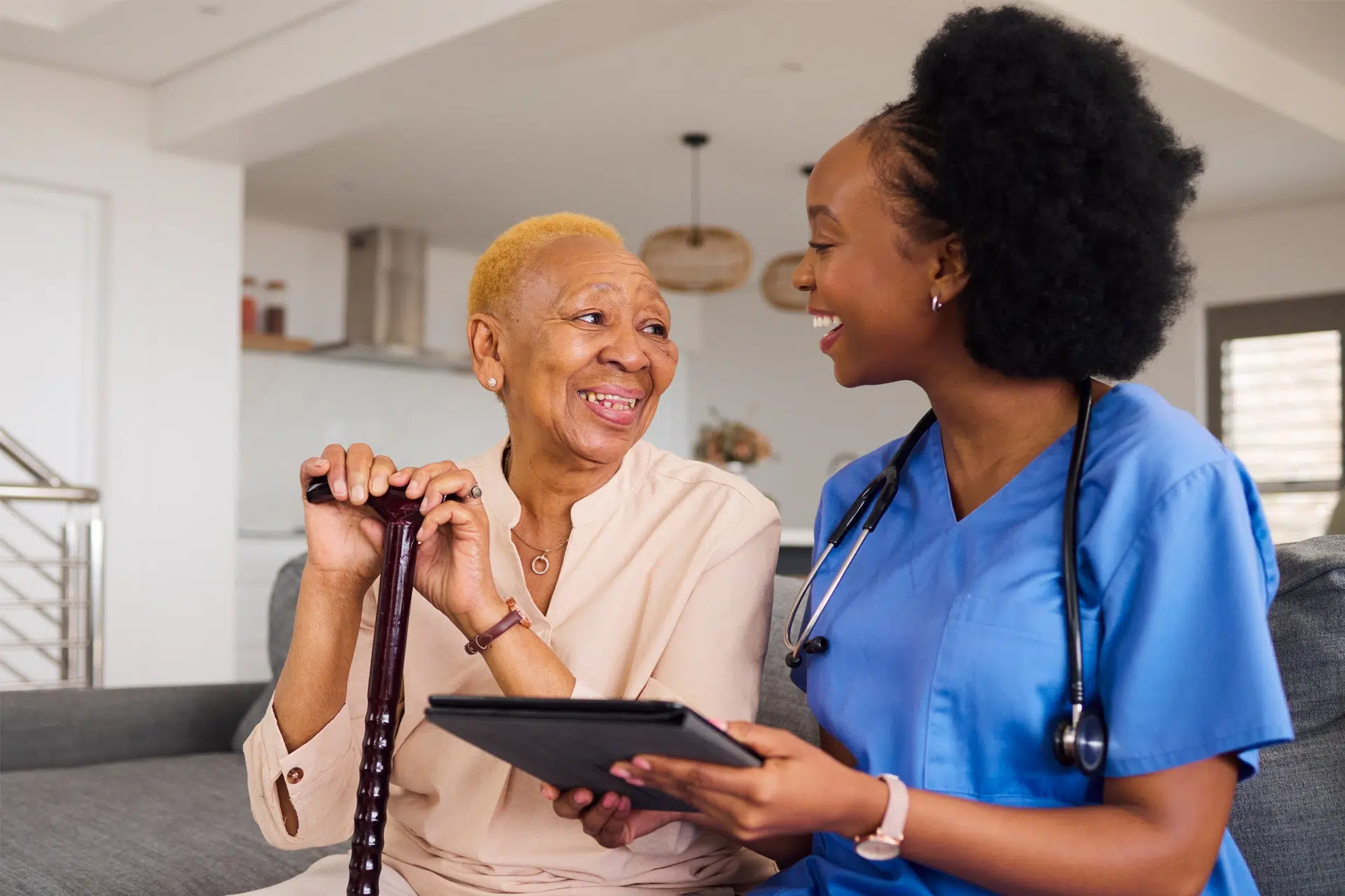Home health nurse supporting an elderly woman during an in-home care visit, reviewing information together in Dallas, Texas