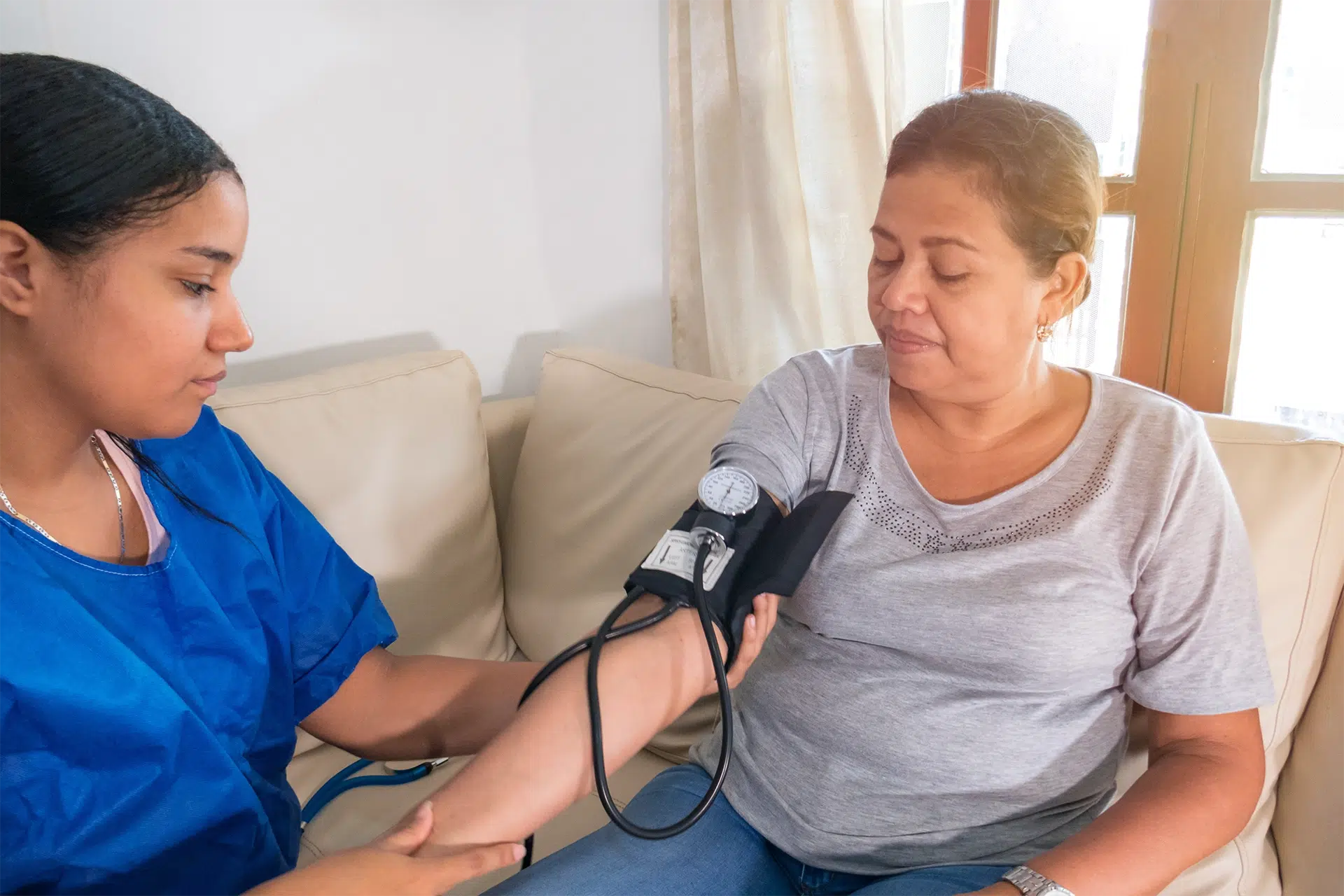 Skilled nurse checking a senior's blood pressure during in-home clinical nursing care in San Antonio, Texas