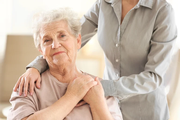 Caregiver offering compassionate in-home care support to an older woman at home