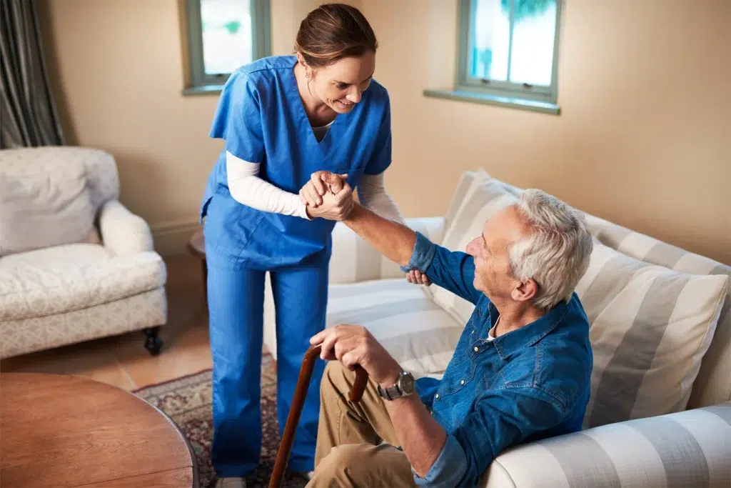 Caregiver helping senior stand safely during in-home personal care support