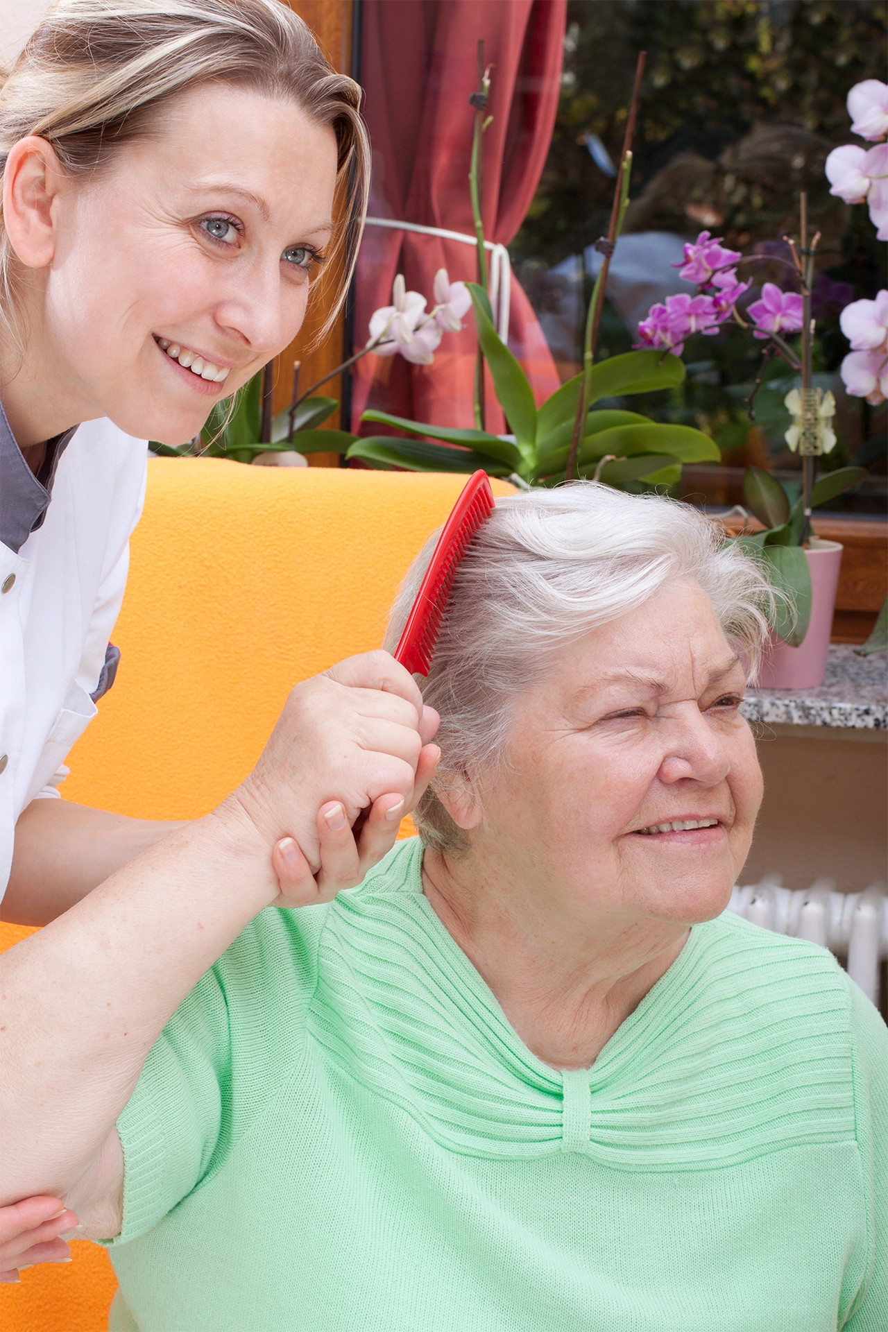 Caregiver assisting an elderly woman with grooming during in-home senior care in Texas.