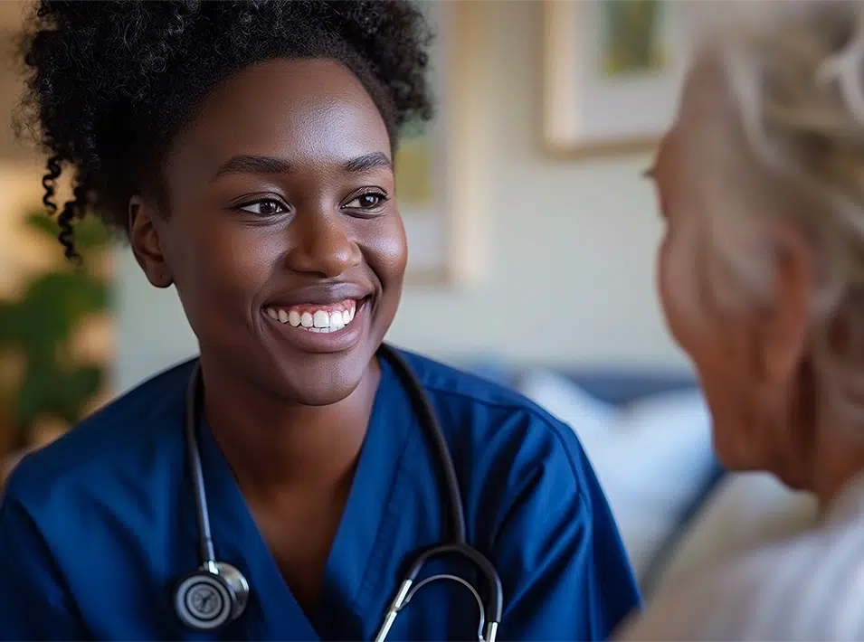 Compassionate home health nurse smiling warmly at an elderly woman during an in-home visit in Texas.
