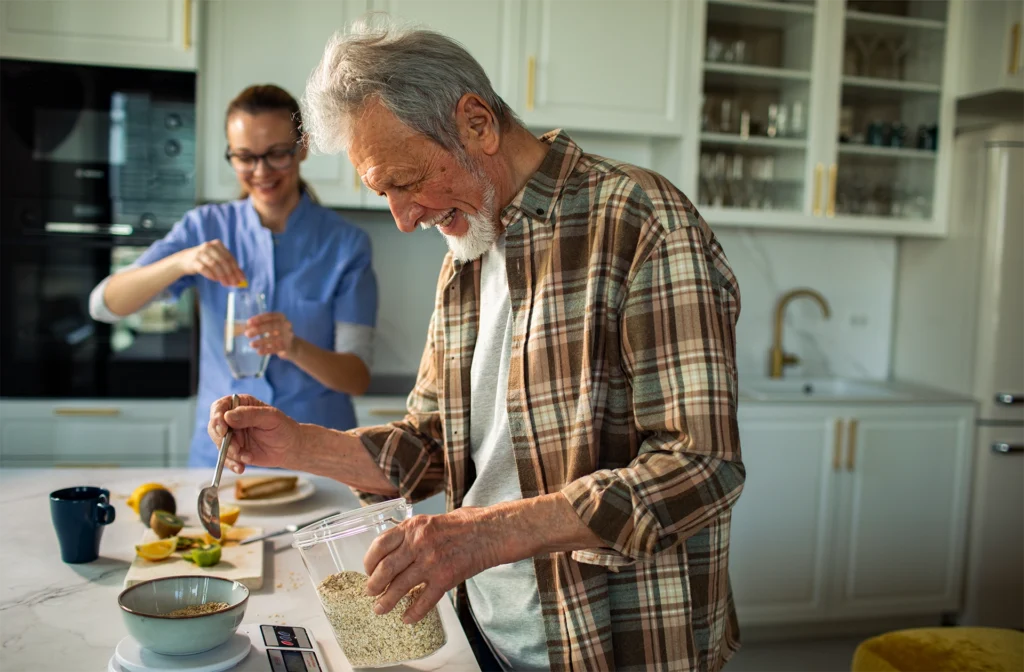 Senior man preparing a meal at home with companion caregiver support in Texas
