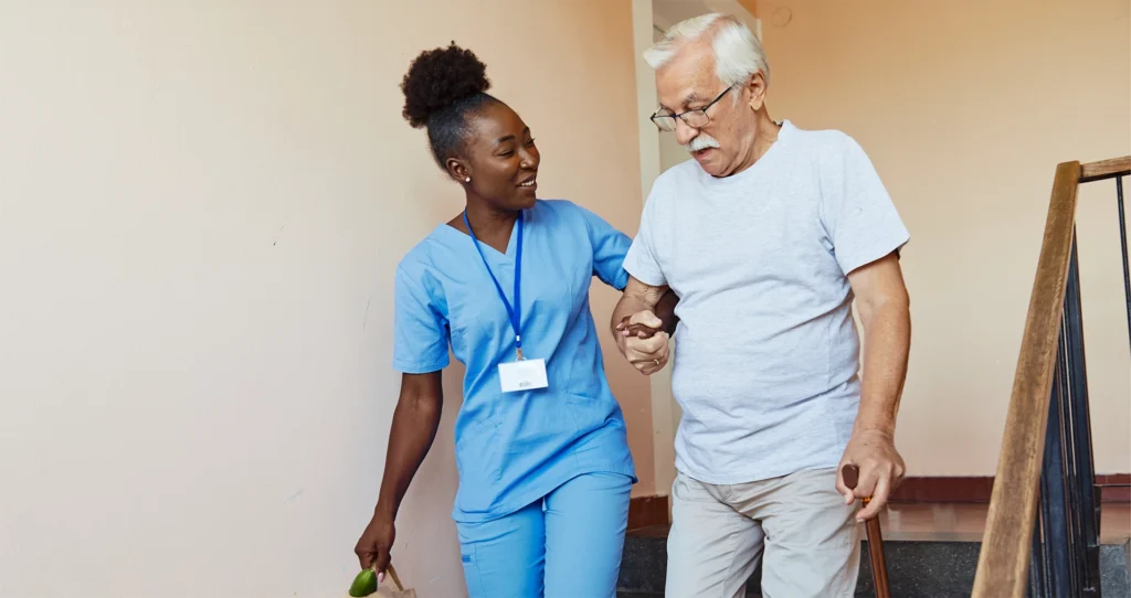 Caregiver assisting senior with stair mobility and fall prevention during home care visit in New Braunfels, Texas